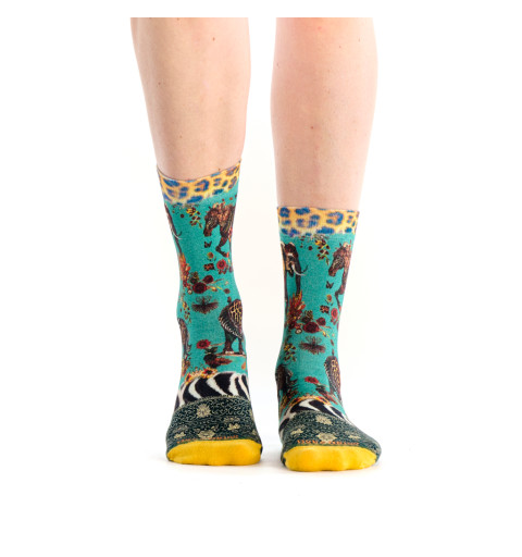 Chaussettes vertes avec des motifs de zèbre et d'éléphant dans un style tapisserie.