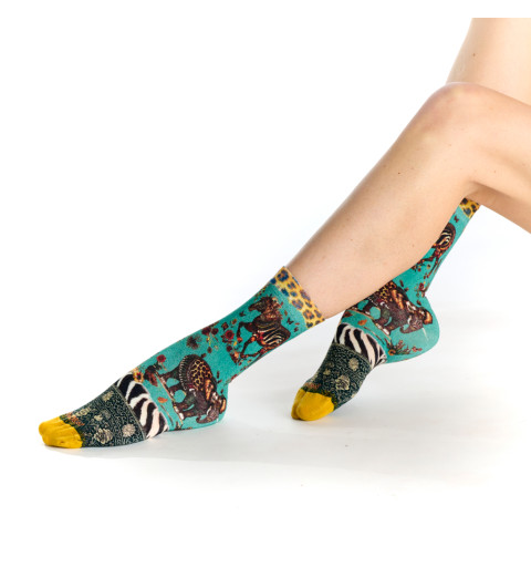 Chaussettes vertes avec des motifs de zèbre et d'éléphant dans un style tapisserie.