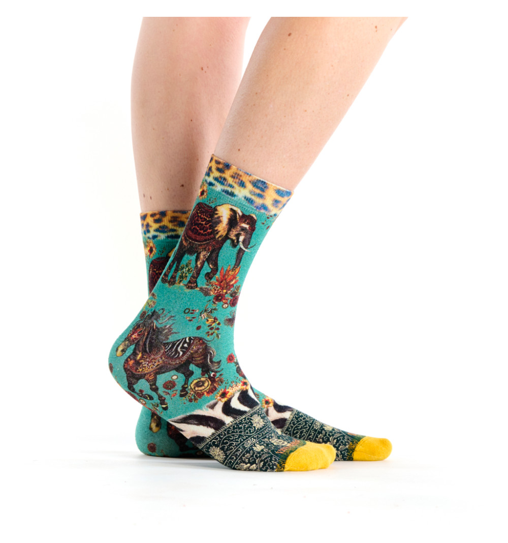 Chaussettes vertes avec des motifs de zèbre et d'éléphant dans un style tapisserie.