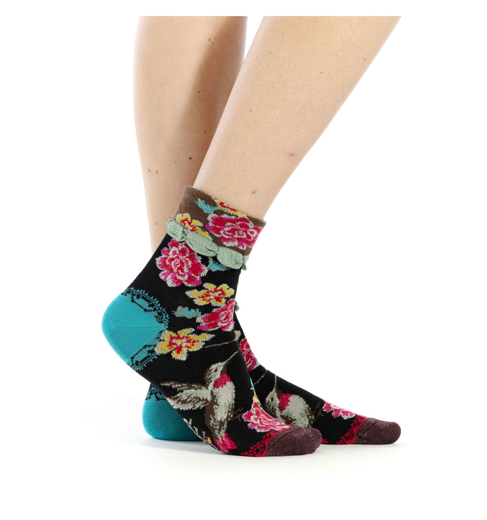 Chaussettes noires Dub & Drino ornées de colibris et fleurs colorées, pointe mauve pailletée, talon cyan et revers marron.