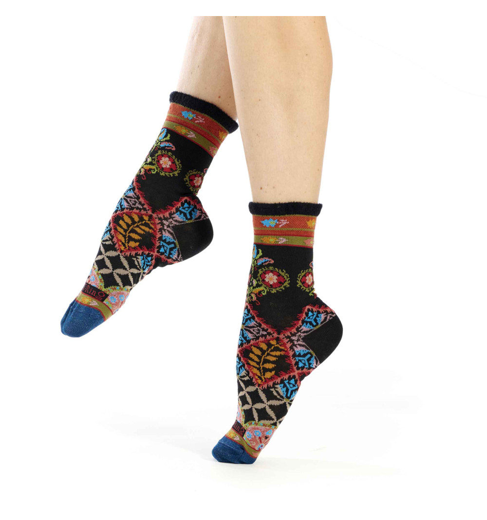 Chaussettes Dub & Drino noires ornées de motifs géométriques et végétaux colorés. Pointe bleue et bord-côte en fil chenille.