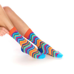 Chaussettes à rayures zigzag Fil de Jour en coton, présentées portées, avec bord-côte orange uni et motif multicolore