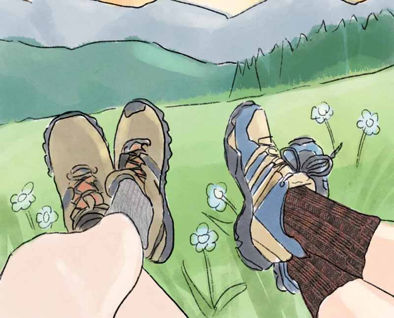 jambes portant des chaussettes de randonnée et des chaussures, tournées vers les montagnes